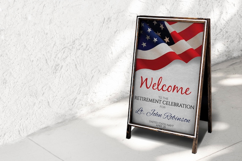 May include: A wooden A-frame sign with a white border and a folded American flag in the background. The sign reads "Welcome to the Retirement Celebration for Lt. John Robinson United States Navy April 30".
