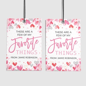 K&ouml;nnte beinhalten: Zwei rosa und wei&szlig;e Geschenkanh&auml;nger mit einem Aquarell-Herz-Muster. Die Anh&auml;nger haben den Text "Das sind ein paar meiner Lieblingssachen." und "Von: Jamie Robinson".