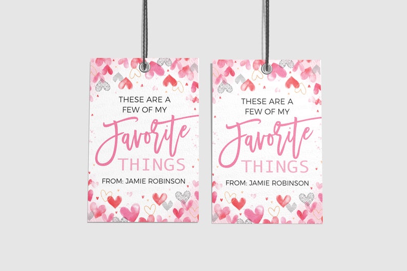 K&ouml;nnte beinhalten: Zwei rosa und wei&szlig;e Geschenkanh&auml;nger mit einem Aquarell-Herz-Muster. Die Anh&auml;nger haben den Text "Das sind ein paar meiner Lieblingssachen." und "Von: Jamie Robinson".