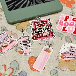 May include: Five colorful bookish themed bookmarks with a clear plastic clip. The bookmarks feature phrases like "Sorry I can't, book boyfriend", "Finish your TBR", "Smutty Book Club", "Spicy Book Club", and "Enemies to lovers, Fated Mates".