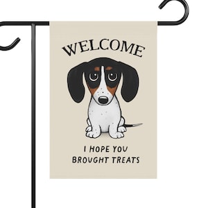 May include: A beige garden flag with a cartoon dachshund and the text "WELCOME I HOPE YOU BROUGHT TREATS".
