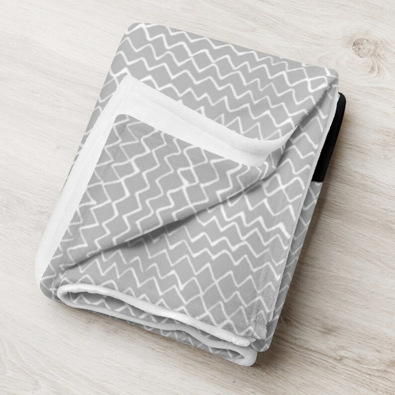 folded blanket with grey and white zigzag pattern