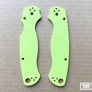 May include: Two lime green knife scales with multiple holes for mounting. The scales are made of a textured material.
