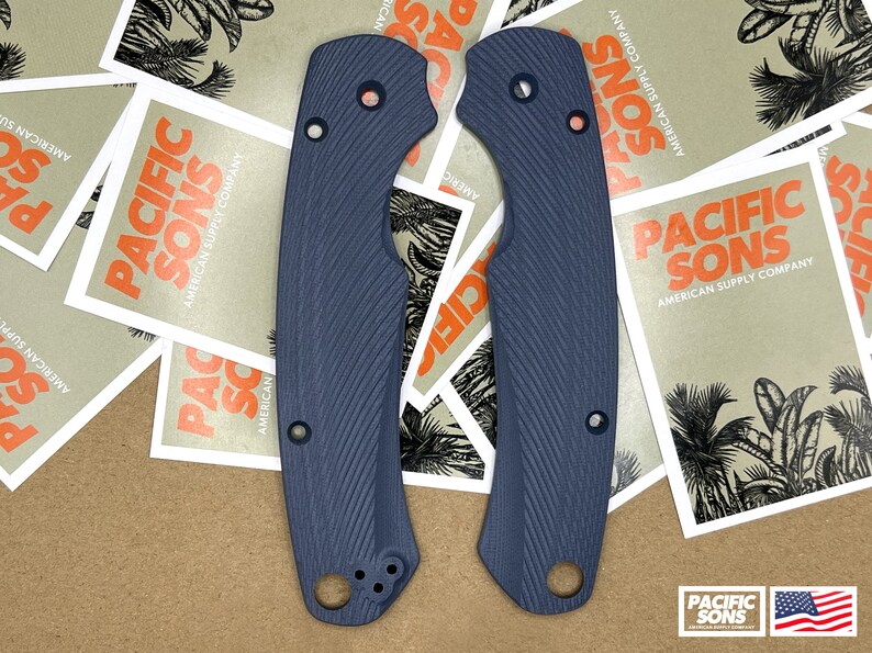 May include: Two dark blue knife scales with a textured pattern. The scales have a rounded shape and are designed to fit a knife handle.
