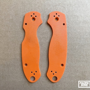 May include: Two orange plastic knife scales with holes for mounting hardware.