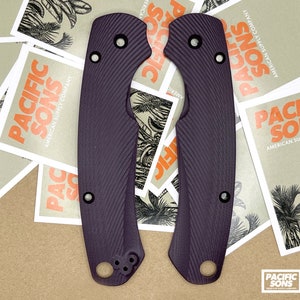 May include: Two purple knife scales with a textured pattern. The scales are made of a durable material and are designed to provide a secure grip.