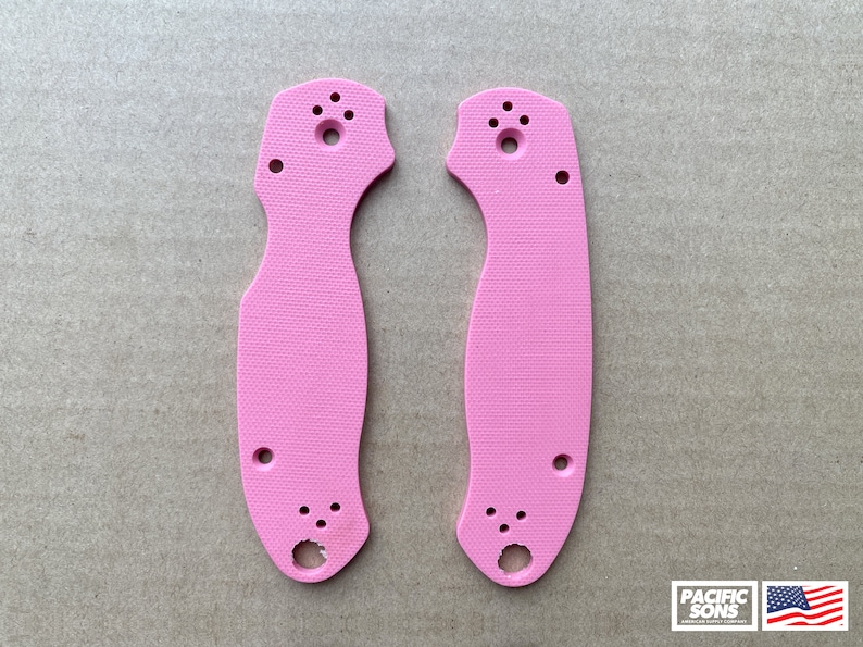 May include: A pair of pink knife scales with a textured surface. The scales have multiple holes for mounting.