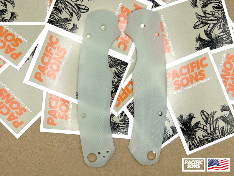 May include: Two white, textured, plastic knife scales. The scales have a pattern of diagonal lines and are designed to fit a knife handle.