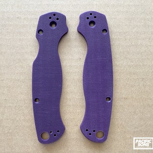 May include: Two purple knife scales with a textured surface and multiple holes for mounting.