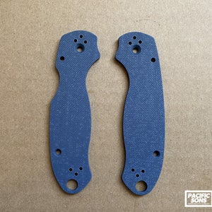 May include: A pair of blue G10 knife scales with a textured surface and multiple holes.