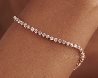 May include: A delicate gold bracelet with a row of sparkling clear round stones.