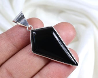 May include: A black gemstone pendant with a silver setting. The pendant is shaped like a diamond and has a pointed tip.