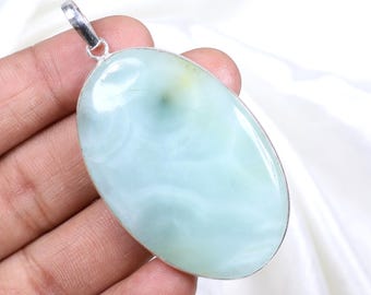 May include: A silver pendant with a light blue oval-shaped gemstone. The gemstone has a swirling pattern.