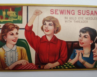 May include: Vintage illustration of three women sewing. The image features the text "Sewing Susan 50 Gold Eye Needles with Threader".