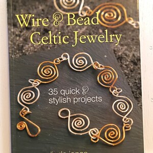 May include: A book titled "Wire & Bead Celtic Jewelry" with gold lettering and a dark background. The cover features a wire jewelry design in gold and silver. The book promises "35 quick & stylish projects" and is authored by Linda Jones.