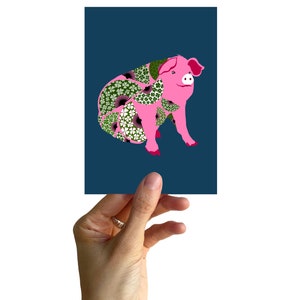 May include: A pink pig with a floral pattern on its body, against a dark blue background.