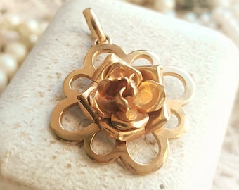 May include: A gold-toned pendant featuring a detailed rose design. The rose is crafted with intricate details and has a delicate, feminine aesthetic.