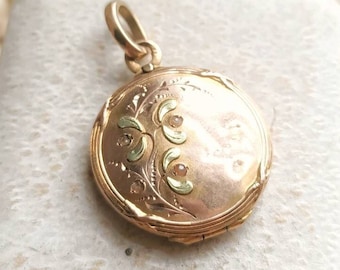 May include: A gold locket with a floral design and small gemstones. The locket is in a white box.