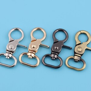 May include: Four metal swivel clasps in silver, gold, black, and antique brass finishes. Each clasp has a D-ring and a trigger snap.