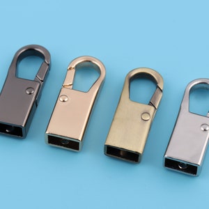 May include: Four metal swivel clasps in different finishes: black, gold, brass, and silver. Each clasp has a rectangular shape with a rounded opening.