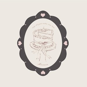 Puede incluir: Ilustración ovalada de un pastel con una porción cortada, adornada con una cereza. El pastel está sobre un plato con un lazo. El marco gris oscuro tiene corazones rosas. El texto dice "may all your wishes come true" y "Manaia".