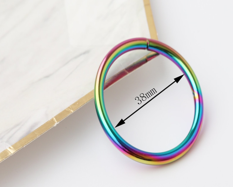 May include: A rainbow-colored metal ring with a diameter of 38mm. The ring is smooth and shiny.