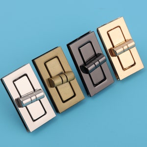 May include: Four metal clasps in different finishes: silver, gold, brass, and black. Each clasp has a rectangular shape with a decorative hinge.