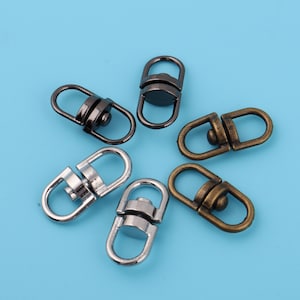 May include: Five swivel clasps in different finishes: silver, black, and bronze. Each clasp has a round swivel and a loop on either end.