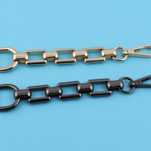 May include: Two metal chain straps with a swivel clasp. The top strap is gold and the bottom strap is black.