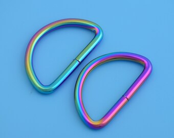 May include: Two rainbow-colored metal D-rings. The rings are about 2 inches in diameter and have a polished finish.