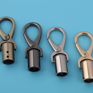 May include: Four metal swivel hooks with a cylindrical base. The hooks are in gold, silver, black, and bronze.