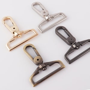 May include: Four metal swivel clasps in different finishes: silver, gold, antique brass, and black. Each clasp has a hook and a D-ring.