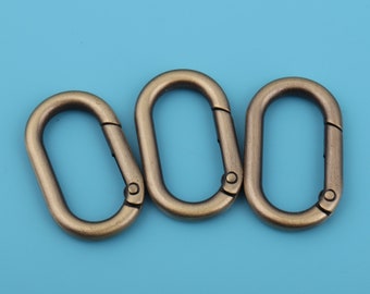 May include: Three antique gold-toned metal oval-shaped clasps with a spring-loaded gate.