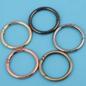 Puede incluir: Cinco llaveros de metal en diferentes colores: negro, dorado, plateado, oro rosa y latón antiguo. Cada llavero tiene un cierre de resorte.