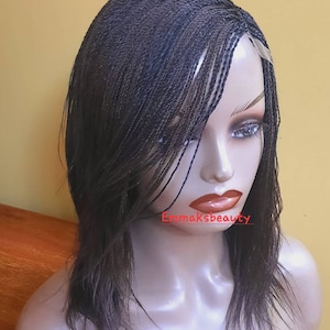 May include: A black wig with micro braids styled in a side part with a lace front. The wig is on a mannequin head.