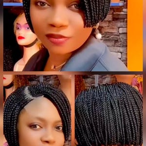 May include: A woman with a short, black braided wig. The wig is styled in a bob cut with a side parting. She is wearing a grey top and a gold necklace. The background features mannequins and shelves.