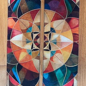 Può includere: Una coppia di stole in tessuto lunghe e rettangolari con un complesso motivo geometrico simmetrico. Il design è composto da cerchi e forme a petalo sovrapposte in tonalità vivaci di arancione, rosso, verde acqua, giallo e marrone scuro con linee bianche.