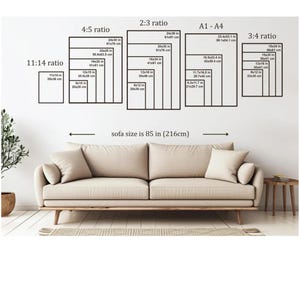 May include: A beige sofa with a light-colored rug and a small side table. Above the sofa, there are several black rectangular frames with size ratios and measurements in inches and centimeters. The text "sofa size is 85 in (216cm)" is also visible.