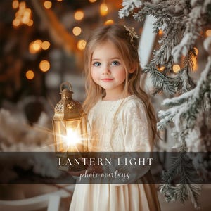 May include: A young girl in a white dress holds a lantern with a warm glow. The lantern is decorated with intricate details and casts a soft light on her face. The background is blurred with warm lights and a snowy pine tree.