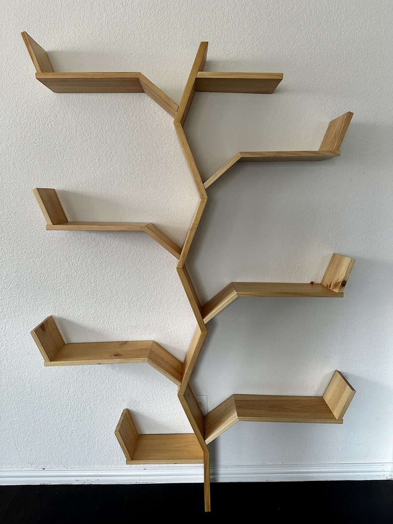 Op de afbeelding: Een houten wandplank met een uniek boomtakontwerp. De plank heeft vijf planken, elk met een andere vorm en grootte. De planken zijn gemaakt van natuurlijk hout en hebben een lichtbruine afwerking.