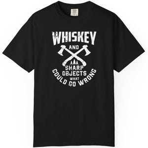 May include: Black t-shirt with a white graphic. The graphic features the words "Whiskey and Sharp Objects" with crossed axes and the phrase "What Could Go Wrong".