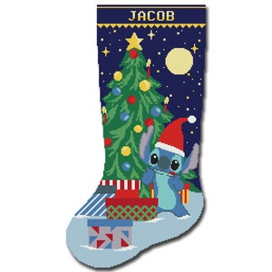 May include: A blue Christmas stocking with a blue alien character holding a gift in front of a green Christmas tree with a yellow star on top. The stocking has the name "JACOB" at the top.