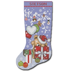 May include: A blue Christmas stocking with the name "STETSON" embroidered on the top. A brown teddy bear with a red Santa hat is holding a red gift box with a white bow. The stocking is decorated with white snowflakes, a green branch with red ornaments, and a gingerbread man.