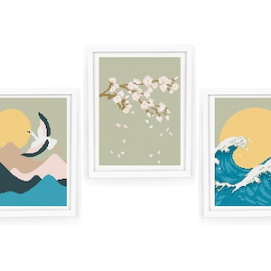 Könnte beinhalten: Drei gerahmte Drucke mit japanischem Thema. Der erste Druck zeigt einen weißen Kranich, der über eine Bergkette fliegt, mit einer gelben Sonne im Hintergrund. Der zweite Druck zeigt einen Zweig mit weißen Kirschblüten, von denen rosa Blütenblätter fallen. Der dritte Druck zeigt eine blaue Welle, die gegen eine gelbe Sonne kracht.