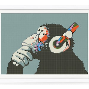 May include: A black and white pixelated image of a monkey wearing headphones with colourful accents. The monkey is looking to the side and has a thoughtful expression.