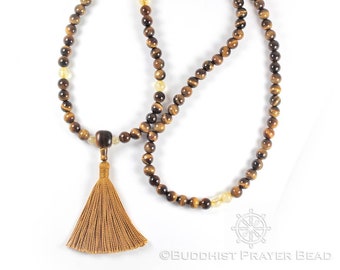 May include: A brown and gold tiger's eye mala prayer bead necklace with a brown tassel. The necklace is made of 108 beads and is approximately 18 inches long.