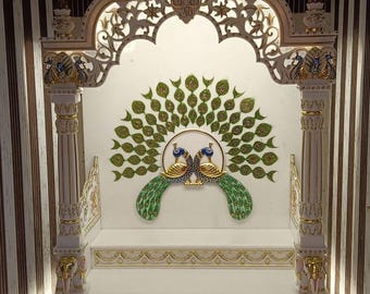 Puede incluir: Templo de madera blanco con tallas intrincadas y detalles dorados. El templo presenta un diseño de pavo real con plumas verdes y azules. El templo está iluminado con luces blancas.