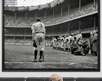 May include: Black and white photograph of a baseball player standing on the field with his team lined up behind him. The player is wearing a baseball uniform with the number 3 on the back. The photograph is taken from behind the player, looking towards the outfield. The stadium is filled with spectators.