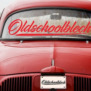 May include: A red vintage car with the words "Oldschoolblech" written in red on the back window and on a license plate.