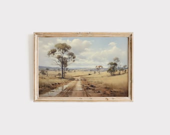 May include: A framed painting depicting a rural landscape with a dirt road leading through a field with trees and a cloudy sky.